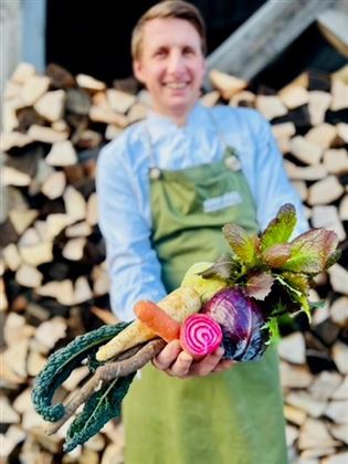 Christoph mit Wintergemüse vor Holz