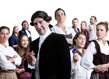 Eine Gruppe von Menschen in historischen Kostümen steht zusammen, einige halten Fläschchen und zeigen verschiedene Gesichtsausdrücke. Die Szenerie vermittelt eine historische oder theatrale Atmosphäre.