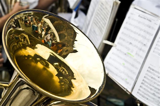 Une tuba brillant avec des détails réfléchissants en métal. En arrière-plan, des feuilles de musique sont visibles.
