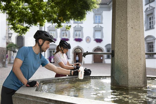 Radfahrende am Brunnen Stiftsplatz Hall