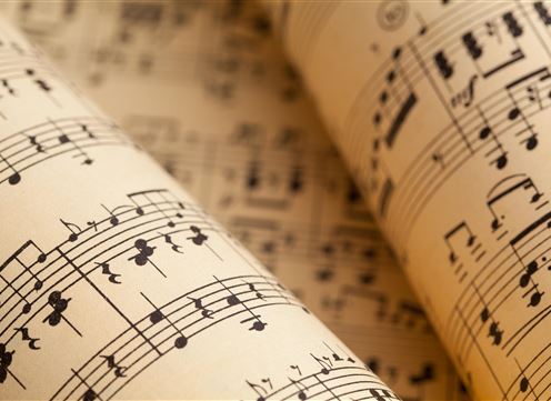 Ein close-up von Notenblättern auf cremefarbenem Papier. Die Noten sind klar und gut lesbar.