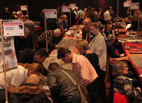 Eine belebte Messe mit vielen Ständen und Besuchern, die Modelle und Sammlerstücke betrachten. Die Atmosphäre ist gesellig und lebhaft.