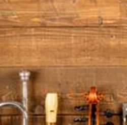 Una collezione di strumenti musicali su un tavolo di legno. Sotto ci sono vari strumenti a corda, strumenti a fiato e strumenti a fiato in legno.