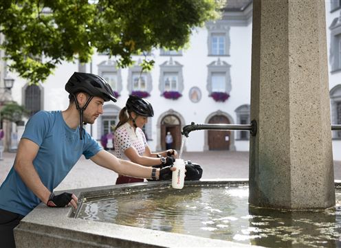 Radfahrende am Brunnen Stiftsplatz Hall