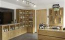 An inviting sales area with wooden shelves displaying various bottles. On the counter, there are additional products and information.