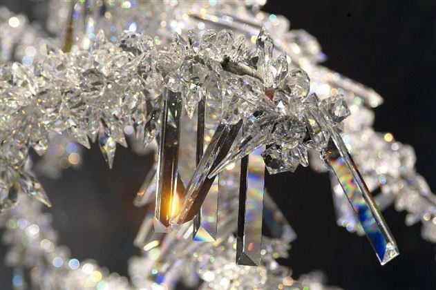 L'ingrandimento di cristallo scintillante mostra forme eleganti e superfici riflettenti. La luce si rifrange e crea un bagliore colorato.