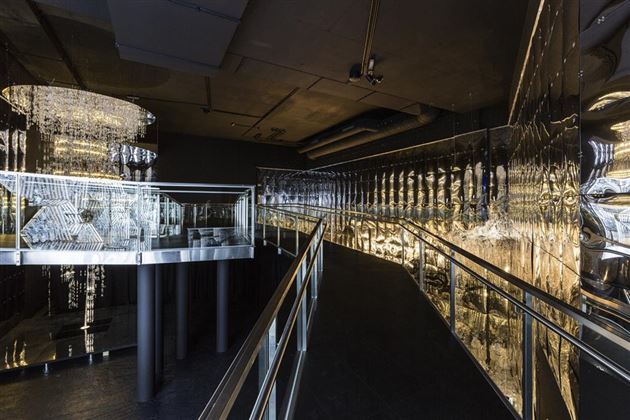Un design d'interni moderno con superfici lucide e una scala elegante. Lo spazio appare stiloso e accogliente, illuminato da fonti di luce scintillanti.