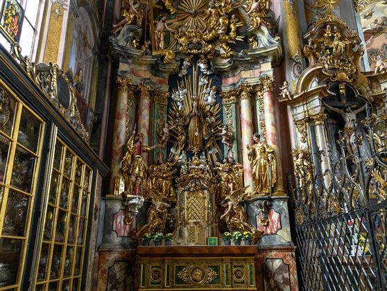 A magnificent altar with golden sculptures and intricate decorations. The colorful walls and windows give the room an impressive atmosphere.