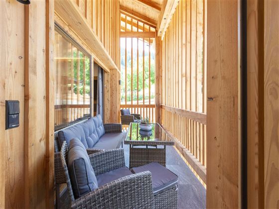 A stylish interior with light wood paneling and a cozy seating group. Large windows ensure plenty of natural light.