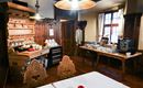 A cozy room with rustic furniture. On a table, there are various foods and drinks for a breakfast buffet.
