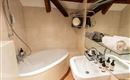 An elegant bathroom with a modern bathtub and a shower. Fresh towels and toiletries are laid out on the sink.