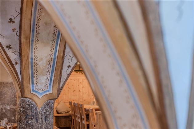 A historic room with gently arched curves and decorative details. The warm lighting creates an inviting atmosphere.