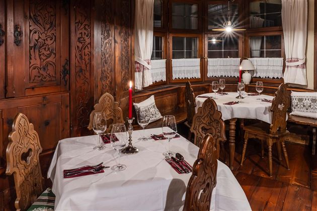 A cozy restaurant with wooden interior and elegant table settings. The atmosphere is warm and inviting, ideal for a romantic dinner.