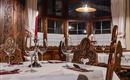 A cozy restaurant with antique wooden interior. Glasses and red candles are on the tables for a romantic atmosphere.
