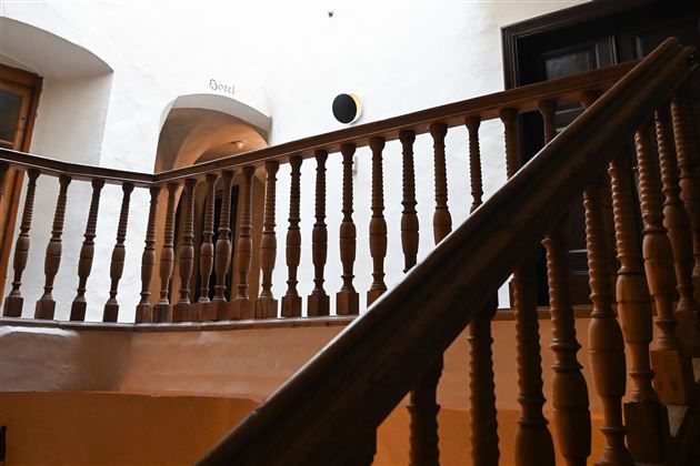 A staircase with a wooden railing and white walls. The light gently falls into the room, creating an inviting atmosphere.