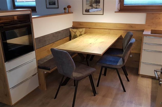 A cozy dining area with a wood-colored table and chairs. The walls are in natural tones, creating a warm atmosphere.