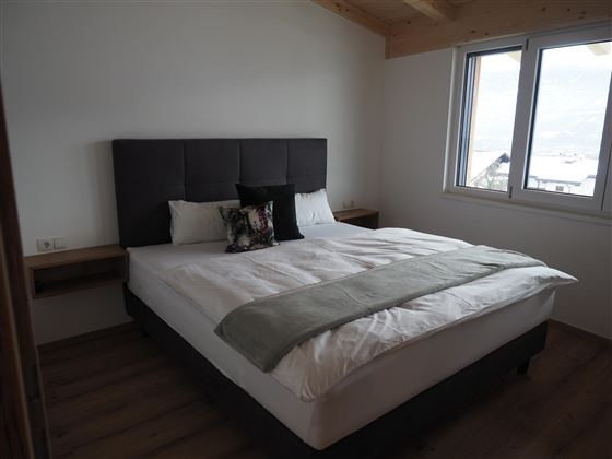 Una camera da letto accogliente con un grande letto e mobili moderni. La finestra offre una bella vista verso l'esterno.