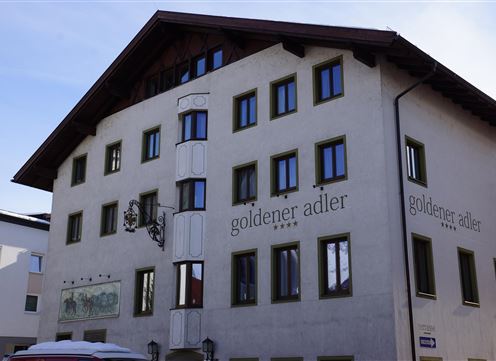 A historic building named "Goldener Adler." It has a traditional façade and many windows.